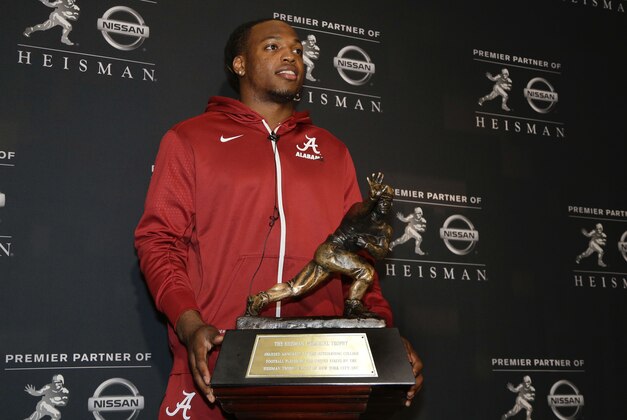 Alabama's Derrick Henry poses for photos with the Heisman Trophy, Friday, Dec. 11, 2015, in New York. Henry, along with Clemson's Deshaun Watson and Stanford's Christian McCaffrey, is a finalist for the trophy which recognizes college football's best player of the year. (AP Photo/Julie Jacobson)