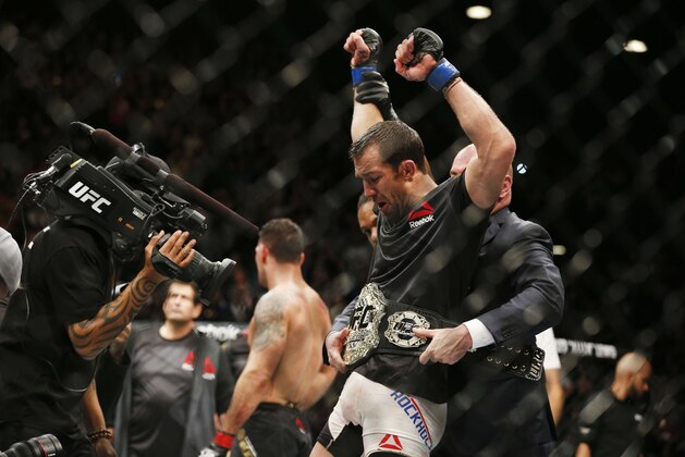 Luke Rockhold, right, reacts after defeating Chris Weidman, left, in a middleweight  championship mixed martial arts bout at UFC 194, Saturday, Dec. 12, 2015, in Las Vegas. (AP Photo/John Locher)