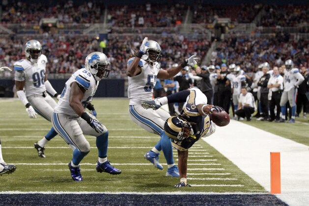 St. Louis Rams running back Todd Gurley, right, scores past Detroit Lions linebacker Josh Bynes, linebacker Stephen Tulloch (55) and Devin Taylor, left, on a 5-yard run during the third quarter of an NFL football game Sunday, Dec. 13, 2015, in St. Louis. (AP Photo/Tom Gannam)