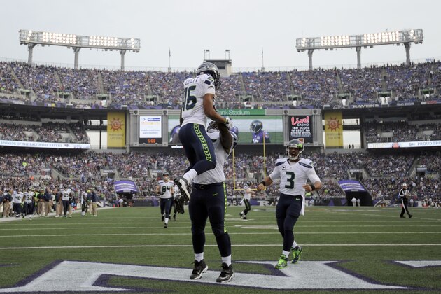 Seattle Seahawks wide receiver Tyler Lockett (16) is picked up by Seahawks center Patrick Lewis (65), as Seattle Seahawks quarterback Russell Wilson (3) comes in to celebrate Lockett's touchdown during the first half an NFL football game against the Baltimore Ravens, Sunday, Dec. 13, 2015, in Baltimore. (AP Photo/Gail Burton)