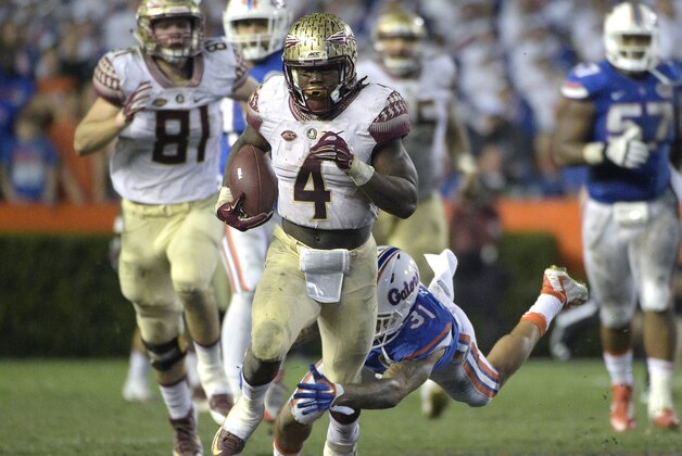 Florida State running back Dalvin Cook (4) rushes for yardage past Florida defensive back Jalen Tabor (31) during the second half of an NCAA college football game in Gainesville, Fla., Saturday, Nov. 28, 2015. Florida State won 27-2. (AP Photo/Phelan M. Ebenhack)