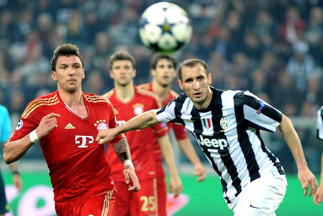 Bayern's Mario Mandzukic of Croatia, center, vies for the ball with Juventus defender Giorgio Chiellini during their Champions League, quarterfinal, second-leg soccer match at the Juventus stadium in Turin, Italy, Wednesday, April 10, 2013. (AP Photo/Massimo Pinca)