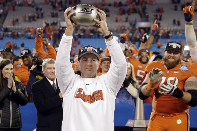 Clemson coach Dabo Swinney holds the championship trophy after Clemson defeated North Carolina in the Atlantic Coast Conference championship NCAA college football game in Charlotte, N.C., early Sunday, Dec. 6, 2015. Clemson won 45-37. (AP Photo/Bob Leverone)