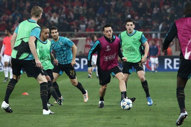 Arsenal's German midfielder Mesut Ozil (3rd R) and others warm up ahead of the UEFA Champions League Group F football match between Olympiacos and Arsenal at the Georgios Karaiskakis Stadium in Piraeus near Athens on December 9, 2015.  AFP PHOTO / ANGELOS TZORTZINIS / AFP / ANGELOS TZORTZINIS        (Photo credit should read ANGELOS TZORTZINIS/AFP/Getty Images)