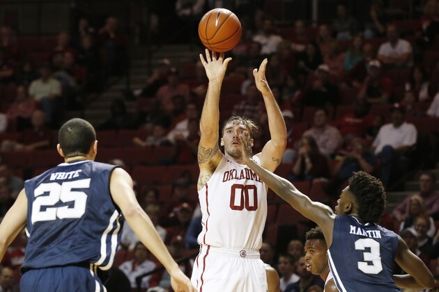 Oklahoma forward Ryan Spangler (00) shoots over Oral Roberts forward Javan White (25) and guard Kris Martin (3) in the second second half of an NCAA college basketball game in Norman, Okla., Saturday, Dec. 12, 2015. Oklahoma won 96-73. (AP Photo/Sue Ogrocki)