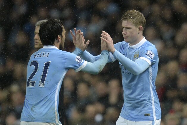 Manchester City's Spanish midfielder David Silva (L) leaves the field substituted and greets his replacement Manchester City's Belgian midfielder Kevin De Bruyne (R) during the English Premier League football match between Manchester City and Swansea City at the Etihad Stadium in Manchester, north west England, on December 12, 2015. AFP PHOTO / OLI SCARFF

RESTRICTED TO EDITORIAL USE. No use with unauthorized audio, video, data, fixture lists, club/league logos or 'live' services. Online in-match use limited to 75 images, no video emulation. No use in betting, games or single club/league/player publications. / AFP / OLI SCARFF        (Photo credit should read OLI SCARFF/AFP/Getty Images)