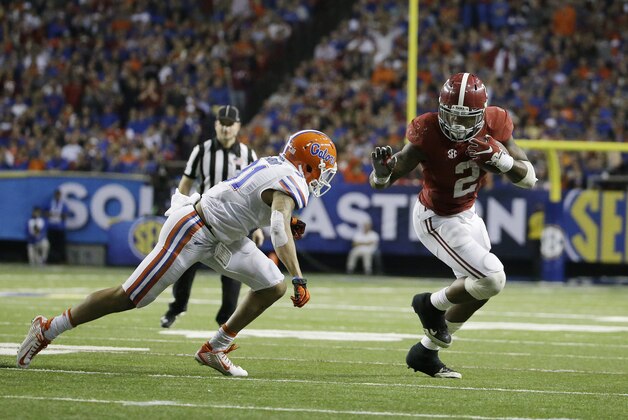 Alabama running back Derrick Henry (2) runs by Florida defensive back Jalen Tabor (31) during the second half of the Southeastern Conference championship NCAA college football game, Saturday, Dec. 5, 2015, in Atlanta. (AP Photo/David Goldman)