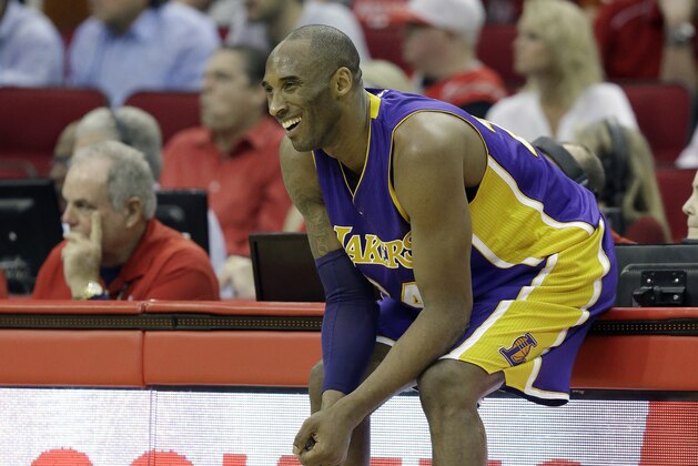 Los Angeles Lakers' Kobe Bryant smiles when he sees former NBA player Tracy McGrady at the NBA basketball game against the Houston Rockets Saturday, Dec. 12, 2015, in Houston. (AP Photo/Pat Sullivan)