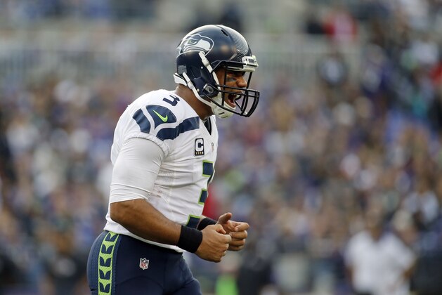 Seattle Seahawks quarterback Russell Wilson reacts after throwing a touchdown pass during an NFL football game against the Baltimore Ravens, Sunday, Dec. 13, 2015, in Baltimore. (AP Photo/Patrick Semansky)