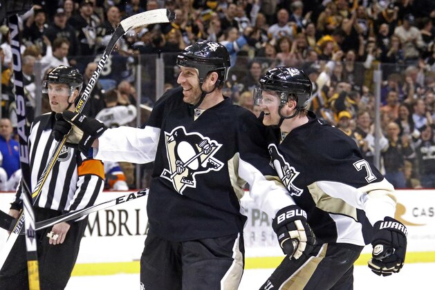 Pittsburgh Penguins' Rob Scuderi (4) celebrates his goal with teammate Paul Martin, right, during the second period of an NHL hockey game against the New York Islanders in Pittsburgh, Friday, April 10, 2015. (AP Photo/Gene J. Puskar)