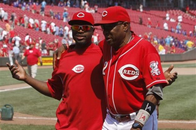 Cincinnati Reds second baseman Brandon Phillips, left, and manager Dusty Baker walk off the field after the Reds beat the San Diego Padres 9-4 in a baseball game, Thursday, Aug. 2, 2012, in Cincinnati. (AP Photo/David Kohl)