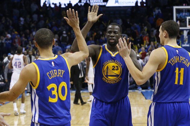 Golden State Warriors' Stephen Curry (30), Draymond Green (23) and Klay Thompson (11) celebrate after defeating the Oklahoma City Thunder in an NBA basketball game in Oklahoma City, Sunday, Nov. 23, 2014. Golden State won 91-86. (AP Photo/Sue Ogrocki)