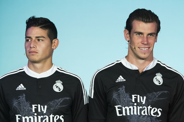 Real's James Rodriguez, left, and Gareth Bale pose for the photographers during the presentation of the Real Madrid's new Champions League kit at the Santiago Bernabeu stadium in Madrid, Spain, Tuesday, Aug. 26, 2014. (AP Photo/Andres Kudacki)