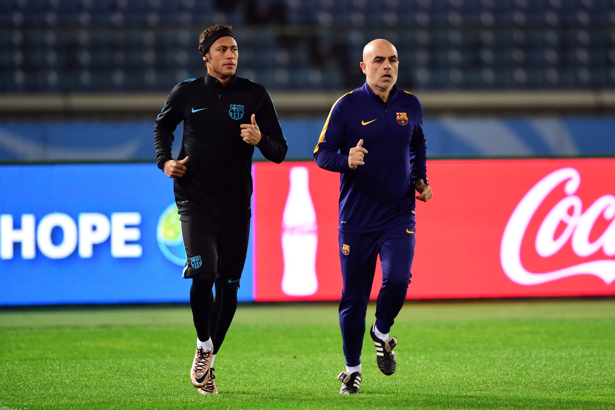 Barcelona forward Neymar (L) jogs with a coach during a football training session in Yokohama, suburban Tokyo on December 16, 2015. Barcelona play against China's Gangzhou Evergrande in the semi-final of the Club World Cup on December 17.   AFP PHOTO / Yoshikazu TSUNO / AFP / YOSHIKAZU TSUNO        (Photo credit should read YOSHIKAZU TSUNO/AFP/Getty Images)