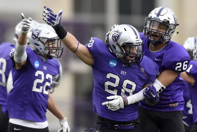 St. Thomas defensive back Jordan Young (22), linebacker Steve Harrell (28) and linebacker Alex Stevson (26) celebrate a fumble recovery by Harrell against the Linfield during the first quarter of a Division III NCAA college football semifinal game on Saturday, Dec. 12, 2015, in St. Paul, Minn. (AP Photo/Hannah Foslien)