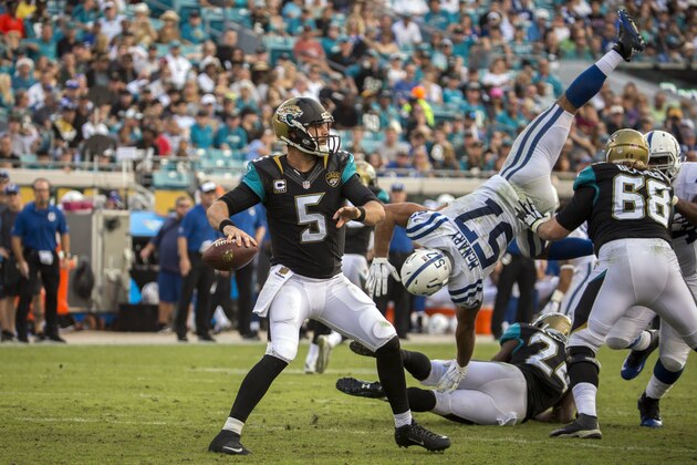 Jacksonville Jaguars quarterback Blake Bortles (5) looks for a receiver as he is pressured by Indianapolis Colts inside linebacker Josh McNary (57) during the second half of an NFL football game in Jacksonville, Fla., Sunday, Dec. 13, 2015. Jacksonville won 51-16. (AP Photo/Stephen B. Morton)