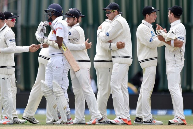 New Zealand celebrate their win as Suranga Lakmal of Sri Lanka (2nd L) shakes the hand of New Zealand's Tom Latham (L) during day five of the first International Test cricket match between New Zealand and Sri Lanka at University Oval in Dunedin on December 14, 2015.   AFP PHOTO / MARTY MELVILLE / AFP / Marty Melville        (Photo credit should read MARTY MELVILLE/AFP/Getty Images)