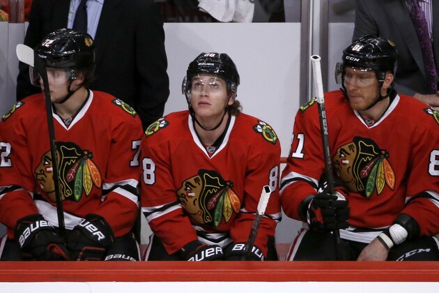 Chicago Blackhawks right wing Patrick Kane, center, looks at the scoreboard on the bench between teammates Artemi Panarin (72) and Marian Hossa (81) during the closing minutes of the third period of an NHL hockey game against the Colorado Avalanche Tuesday, Dec. 15, 2015, in Chicago. The Avalanche won 3-0, ending Kane's consecutive points streak at 26 games.  (AP Photo/Charles Rex Arbogast)