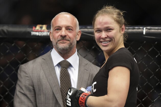 Ronda Rousey, right, smiles with UFC owner Lorenzo Fertitta following her UFC 170 mixed martial arts women's bantamweight title fight against Sara McMann on Saturday, Feb. 22, 2014, in Las Vegas. (AP Photo/Isaac Brekken)
