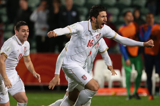Marko Grujic of Serbia (R) leads teammates as they celebrate their victory during a penalty shootout during the FIFA U20 World Cup quarter-final match between the USA and Serbia in Auckland on June 14, 2015.     AFP PHOTO / Fiona GOODALL        (Photo credit should read Fiona GOODALL/AFP/Getty Images)