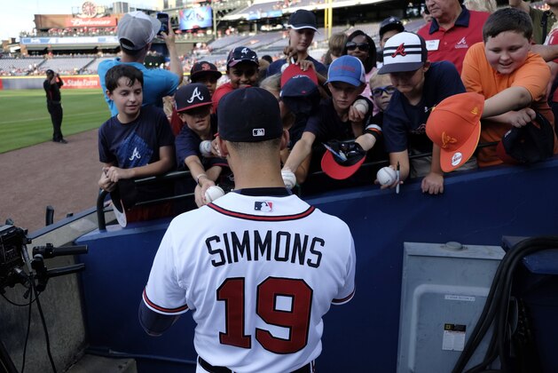 Former Atlanta Braves shortstop Andrelton Simmons (19) signs autographs for fans before a baseball game against the Miami Marlins, Friday, Aug. 7, 2015, in Atlanta. (AP Photo/Brett Davis)