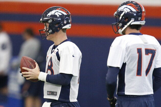 Denver Broncos quarterback Peyton Manning, left, looks to pass the ball as quarterback Brock Osweiler looks on during a practice at the team's headquarters Wednesday, Dec.16, 2015, in Englewood, Colo. (AP Photo/David Zalubowski)