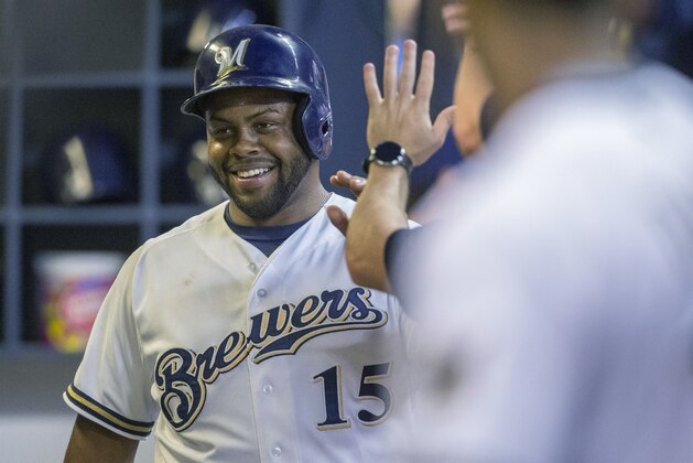 Milwaukee Brewers' Jason Rogers is greeted in the dugout by teammates after scoring against the Pittsburgh Pirates during the fourth inning of a baseball game, Thursday, Sept. 3, 2015, in Milwaukee. (AP Photo/Tom Lynn)