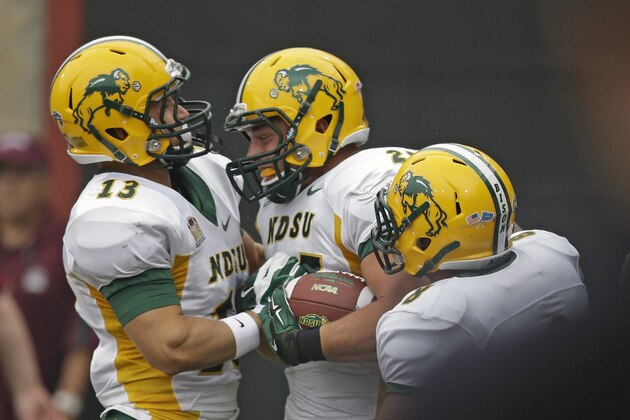 North Dakota State's running back Chase Morlock, center, celebrates with teammates Eric Perkins (13) and Darius Anderson (8)  scores during the first half of an NCAA college football game against Montana Saturday, Aug. 29, 2015, in Missoula, Mont.  (AP Photo/Rick Bowmer)