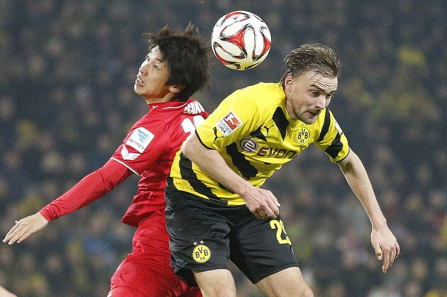 Dortmund's Marcel Schmelzer, right, and Cologne's Yuya Osako challenge for the ball during the German first division Bundesliga soccer match between BvB Borussia Dortmnd and 1.FC Cologne in Dortmund, Germany, Saturday, March 14, 2015. (AP Photo/Frank Augstein)