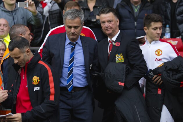 Chelsea's manager Jose Mourinho, center left, makes his way from the opposition dugout after greeting Manchester United manager Louis van Gaal, centre right, during their English Premier League soccer match between Manchester United and Chelsea at Old Trafford Stadium, Manchester, England, Sunday Oct. 26, 2014. (AP Photo/Jon Super)
