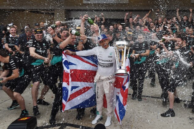 Mercedes AMG Petronas driver Lewis Hamilton of Britain celebrates with team members in the pit lane after winning the United States Formula One Grand Prix and the Drivers Championships at the Circuit of The Americas in Austin, Texas on October 25, 2015.                  AFP PHOTO / MARK RALSTON        (Photo credit should read MARK RALSTON/AFP/Getty Images)