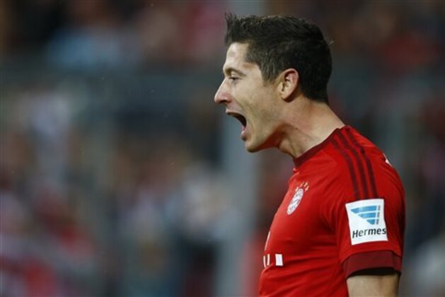 Bayern's Robert Lewandowski celebrates after scoring during the German Bundesliga soccer match between FC Bayern Munich and VfL Wolfsburg at the Allianz Arena stadium in Munich, Germany, Tuesday, Sept. 22, 2015. Lewandowski made Bundesliga history on Tuesday after scoring five goals in the space of nine minutes as Bayern Munich came from behind to rout Wolfsburg 5-1 and move to the top of the standings. (AP Photo/Matthias Schrader)