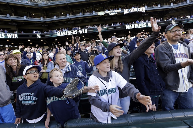 Fans reach for memorabilia tossed to them after a Seattle Mariners baseball game Sunday, Oct. 4, 2015, in Seattle. The Mariners won 3-2. (AP Photo/Elaine Thompson)