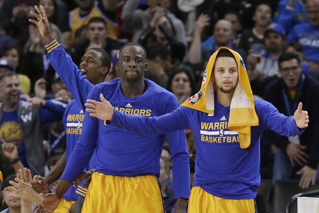 Golden State Warriors guard Stephen Curry, right, celebrates on the bench with forward Draymond Green, center, and forward Harrison Barnes during the second half of an NBA basketball game against the Los Angeles Lakers in Oakland, Calif., Tuesday, Nov. 24, 2015. The Warriors won 111-77. (AP Photo/Jeff Chiu)