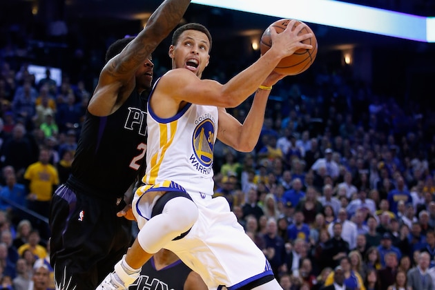 OAKLAND, CA - DECEMBER 16:  Stephen Curry #30 of the Golden State Warriors goes up for a shot against Eric Bledsoe #2 of the Phoenix Suns at ORACLE Arena on December 16, 2015 in Oakland, California.  NOTE TO USER: User expressly acknowledges and agrees that, by downloading and or using this photograph, User is consenting to the terms and conditions of the Getty Images License Agreement.  (Photo by Ezra Shaw/Getty Images)