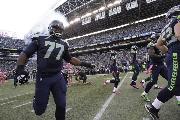 Seattle Seahawks players including defensive tackle Ahtyba Rubin (77) take the field for an NFL football game against the Detroit Lions, Monday, Oct. 5, 2015, in Seattle. (AP Photo/Elaine Thompson)