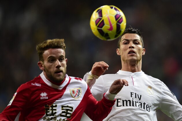 Real Madrid's Portuguese forward Cristiano Ronaldo (R) vies with Rayo Vallecano's defender Quini during the Spanish league football match Real Madrid CF vs Rayo Vallecano at the Santiago Bernabeu stadium in Madrid on November 8, 2014.   AFP PHOTO/ JAVIER SORIANO        (Photo credit should read JAVIER SORIANO/AFP/Getty Images)