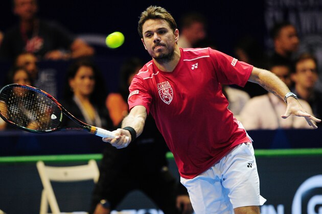 Switzerland's Stan Wawrinka of Singapore Slammers hits a return against Australia's Bernard Tomic of Indian Aces during their men's singles tennis match at the International Premier Tennis League (IPTL) tournament in Singapore on December 19, 2015. AFP PHOTO /MOHD FYROL / AFP / MOHD FYROL        (Photo credit should read MOHD FYROL/AFP/Getty Images)