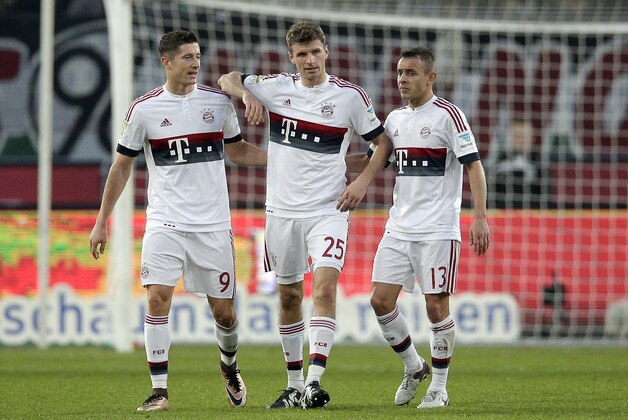 Bayern's Robert Lewandowski, Thomas Mueller and Rafinha, from left, walk on the pitch after Mueller scored the opening goal by penalty during the German Bundesliga soccer match between Hannover 96 and FC Bayern Munich in Hannover, Germany, Saturday, Dec. 19, 2015. (AP Photo/Michael Sohn)