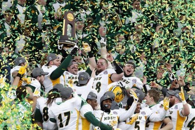 FILE - In this Jan. 10, 2015 file photo, members of the North Dakota State football team hold the championship trophy after their 29-27 win over Illinois State in the FCS Championship NCAA college football game in Frisco, Texas. A poll of league coaches, media and sports information directors released Monday, July 27, 2015, shows that four-time defending FCS winner North Dakota State is favored to win the Missouri Valley Football Conference. (AP Photo/Tim Sharp, File)