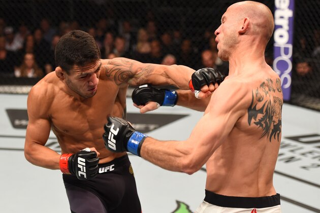 ORLANDO, FL - DECEMBER 19:   (L-R) Rafael dos Anjos punches Donald Cerrone in their UFC lightweight title bout during the UFC Fight Night event at the Amway Center on December 19, 2015 in Orlando, Florida. (Photo by Josh Hedges/Zuffa LLC/Zuffa LLC via Getty Images)