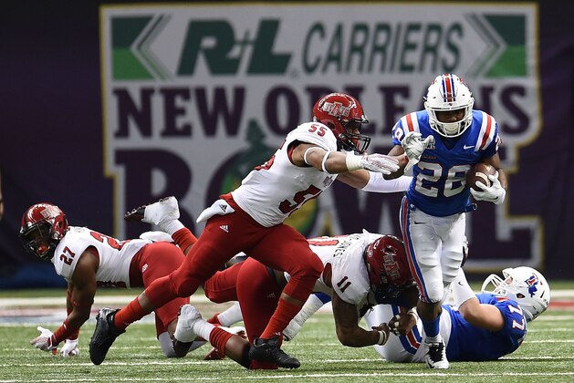 NEW ORLEANS, LA - DECEMBER 19:  Kenneth Dixon #28 of the Louisiana Tech Bulldogs is pursued by Xavier Woodson-Luster #55 of the Arkansas State Red Wolves during the second quarter of the R+L Carriers New Orleans Bowl at the Mercedes-Benz Superdome on December 19, 2015 in New Orleans, Louisiana.  (Photo by Stacy Revere/Getty Images)