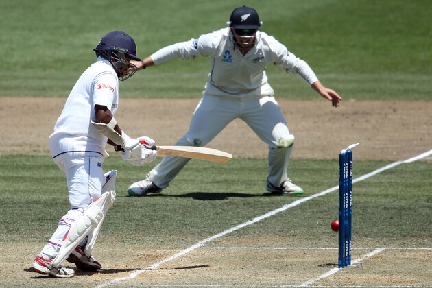 Rangana Herath of Sri Lanka (L) watches the ball hits the stumps as Tom Latham of New Zealand (R) looks on during day three of the second Test cricket match between New Zealand and Sri Lanka at Seddon Park in Hamilton on December 20, 2015.       AFP PHOTO / MICHAEL BRADLEY / AFP / MICHAEL BRADLEY        (Photo credit should read MICHAEL BRADLEY/AFP/Getty Images)