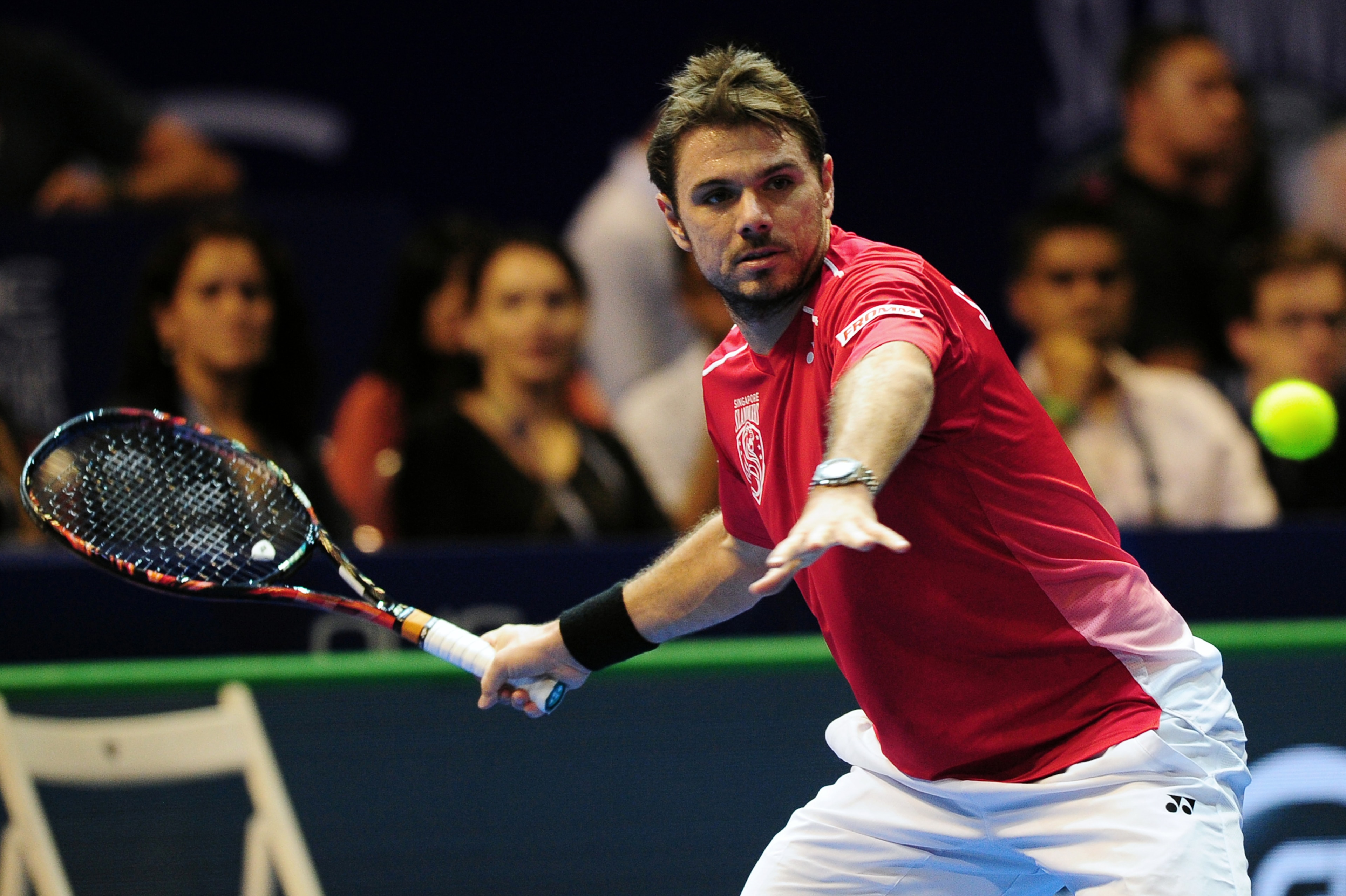 Switzerland's Stan Wawrinka of Singapore Slammers hits a return against Australia's Bernard Tomic of Indian Aces during their men's singles tennis match at the International Premier Tennis League (IPTL) tournament in Singapore on December 19, 2015. AFP PHOTO /MOHD FYROL / AFP / MOHD FYROL        (Photo credit should read MOHD FYROL/AFP/Getty Images)
