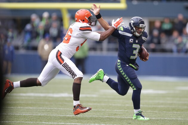 Seattle Seahawks quarterback Russell Wilson pushes off of Cleveland Browns' Karlos Dansby in the first half of an NFL football game, Sunday, Dec. 20, 2015, in Seattle. (AP Photo/Scott Eklund)