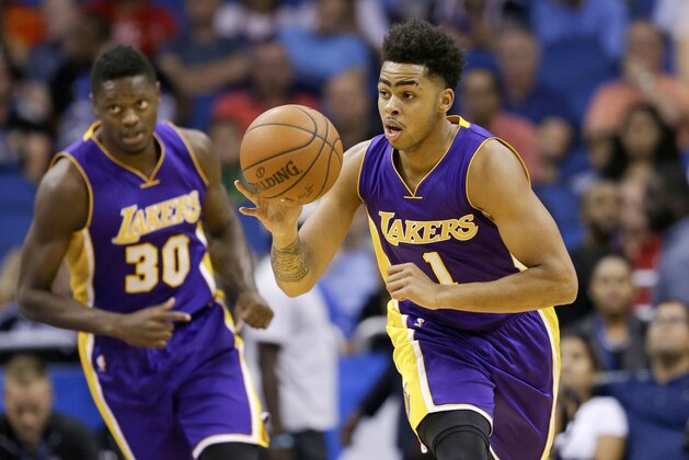 Los Angeles Lakers guard D'Angelo Russell (1) brings the ball downcourt against the Orlando Magic as teammate Los Angeles Lakers forward Julius Randle (30) follows during the first half of an NBA basketball game, Wednesday, Nov. 11, 2015, in Orlando, Fla. (AP Photo/John Raoux)