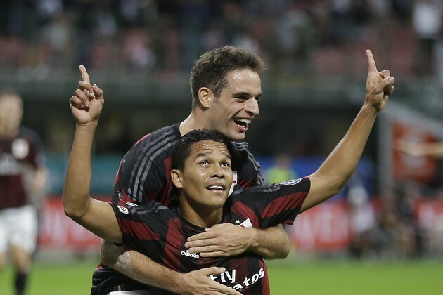 AC Milan's Carlos Bacca kneels in celebration joined by his teammate Giacomo Bonaventura after scoring during the Serie A soccer match between AC Milan and Palermo at the San Siro stadium in Milan, Italy, Saturday, Sept. 19, 2015. (AP Photo/Antonio Calanni)