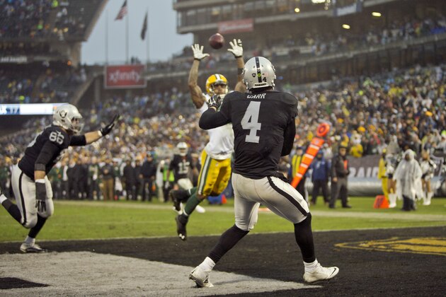 OAKLAND, CA - DECEMBER 20:  Quarterback Derek Carr #4 of the Oakland Raiders throws from the end zone to wide receiver Michael Crabtree #15 through the arms of safety Morgan Burnett #42 of the Green Bay Packers with just over two minutes to play on December 20, 2015 at O.co Coliseum in Oakland, California.  The Packers won 30-20.  (Photo by Brian Bahr/Getty Images)