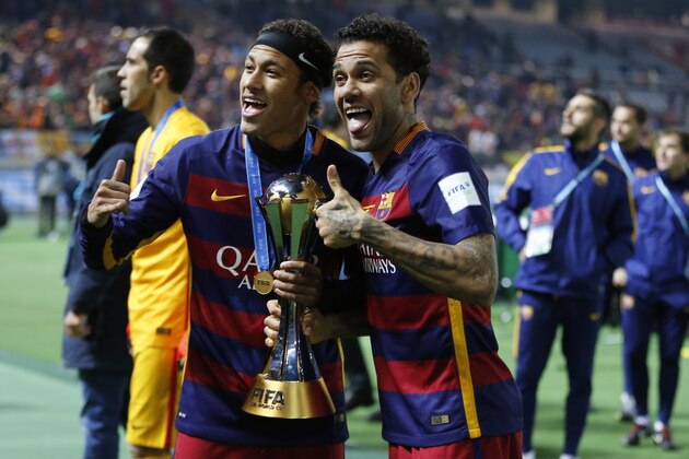 FC Barcelona's Neymar, left, and  Dani Alves hold a trophy after winning the final match against River Plate at the FIFA Club World Cup soccer tournament in Yokohama, near Tokyo, Sunday, Dec. 20, 2015. (AP Photo/Shuji Kajiyama)