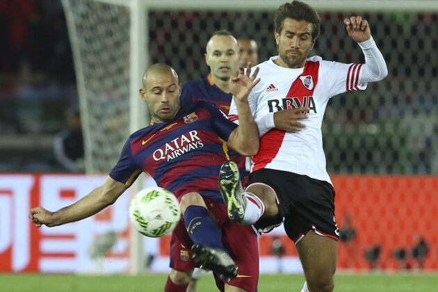 FC Barcelona’s Javier Mascherano of Argentina, left, and River Plate’s Sebastian Driussi charge the ball during their final match at the FIFA Club World Cup soccer tournament in Yokohama, near Tokyo, Japan, Sunday, Dec. 20, 2015. (AP Photo/Eugene Hoshiko)